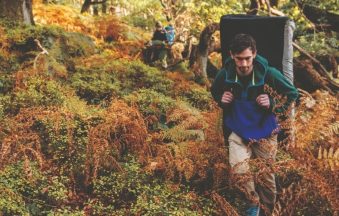 A man hiking and carrying a bouldering crash